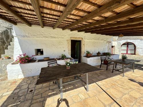 a patio with two tables and a wooden ceiling at Masseria Ferri in Ostuni