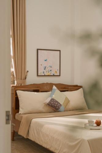 a bedroom with a bed with pillows on it at Oliu Home Đà Lạt in Xuan An