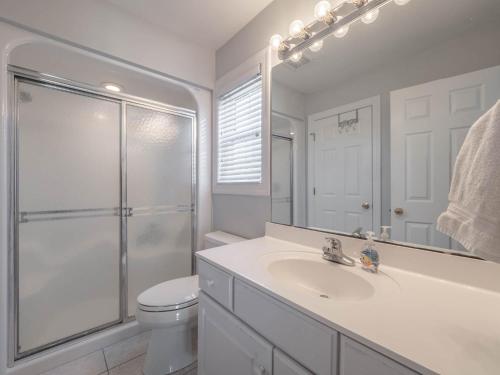 a bathroom with a toilet and a sink and a shower at Serendipity in Surf City