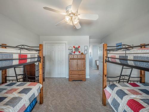 a bedroom with two bunk beds and a ceiling fan at Serendipity in Surf City