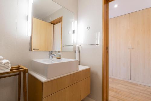a bathroom with a white sink and a refrigerator at S1405 - practical and modern - AC, balcony and parking in Porto