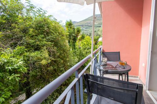 a balcony with a table and an umbrella at Aurora Premium Hospitality in Parga