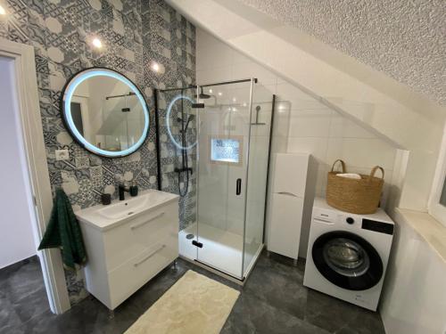 a bathroom with a sink and a washing machine at Penthouse Vanja in Bol