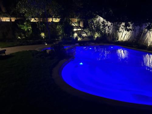 a large blue swimming pool at night at Le Relais du Lierre in Poggio