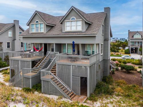 a large house with stairs in front of it at Serenity Now in Topsail Beach