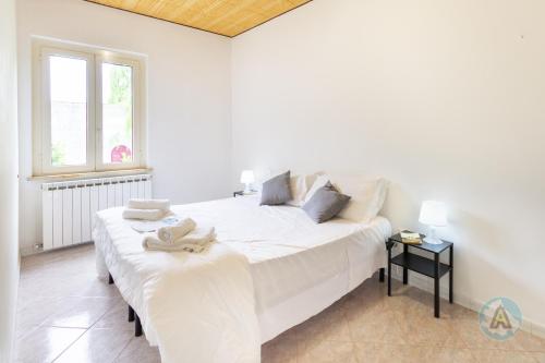 a white bed in a room with a window at Villetta a schiera nella Pineta di Silvi Marina in Silvi Marina