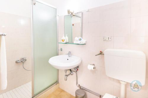 a white bathroom with a sink and a shower at Villetta a schiera nella Pineta di Silvi Marina in Silvi Marina