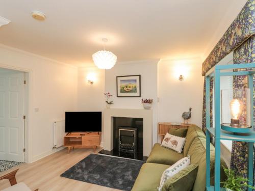 a living room with a couch and a fireplace at Little Nest Cottage in Guisborough