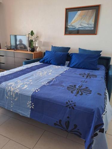 - un lit bleu avec une couette bleue dans l'établissement Studio terrasse face à la plage JUAN LES PINS, à Antibes