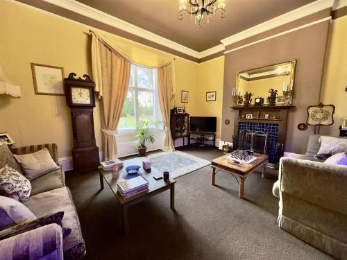 a living room with a couch and a table at Calthwaite Hall Bed & Breakfast in Penrith