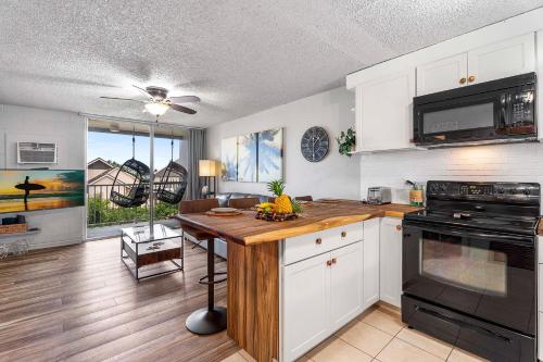 a kitchen with white cabinets and a wooden counter top at Kailua Village#201 in Kailua-Kona