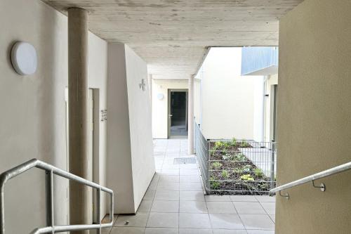 a hallway of a building with stairs and plants at Modernes Studio beim Domplatz in Wiener Neustadt