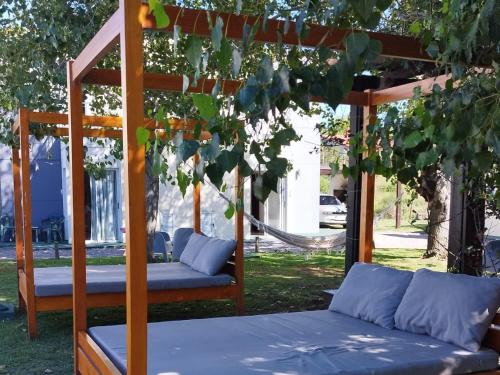 a wooden bed with a canopy in a garden at Las Martinas Piriapolis in Piriápolis