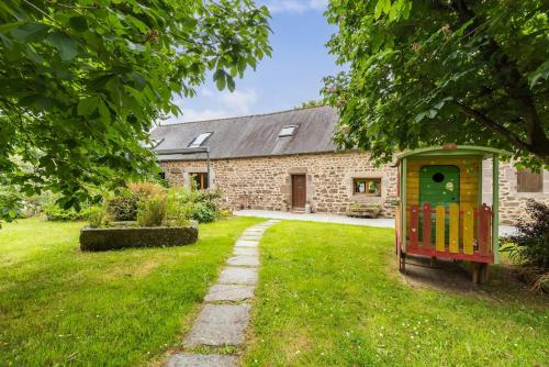 a house with a toy train in the yard at Chez Papitou - Escapade Familiale en Bretagne in Saint-Adrien