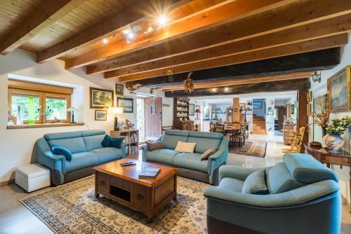 a living room with blue couches and a table at Chez Papitou - Escapade Familiale en Bretagne in Saint-Adrien