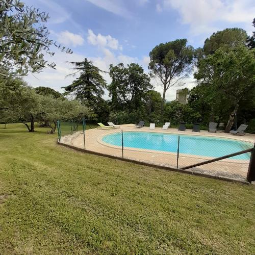 une piscine entourée d'une clôture dans l'établissement Le Mas David, à Vézénobres