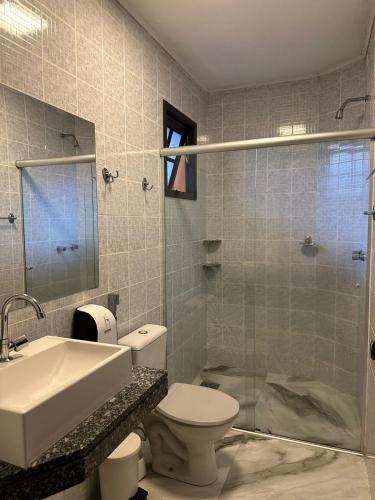 ein Badezimmer mit Toilette, Waschbecken und Dusche in der Unterkunft Hotel Pousada dos Condes in Maresias