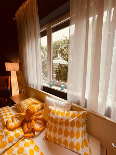 a teddy bear laying on a bed next to a window at Opal in Klagenfurt