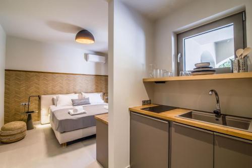 a kitchen with a bed and a sink in a room at blue symphony suites and apartments in Nikiana