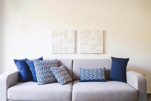 a couch with pillows on it in a living room at blue symphony suites and apartments in Nikiana
