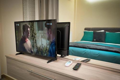 a flat screen tv sitting on a dresser with a bed at Eugenia's Luxury Apart in Volos