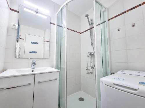 une salle de bain blanche avec une douche et un lavabo dans l'établissement Escale Azur - Mazet avec jardin, wifi, piscine, au Lavandou