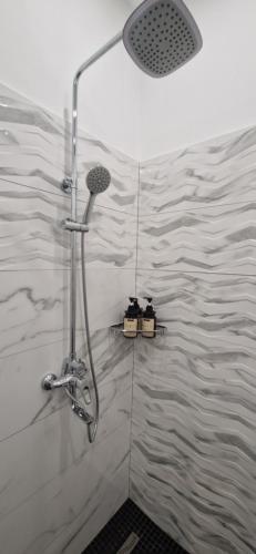 een douche met een douchekop in de badkamer bij Токио 3 in Astana