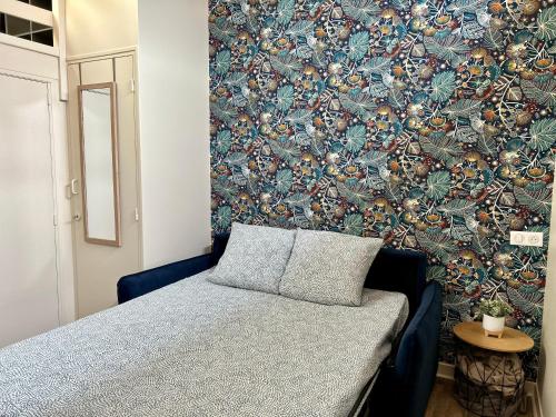 - une chambre avec un lit bleu et un mur dans l'établissement Votre duplex en hypercentre !, à La Rochelle