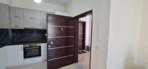 a kitchen with a wooden door and a stove at View Saranda Center in Sarandë