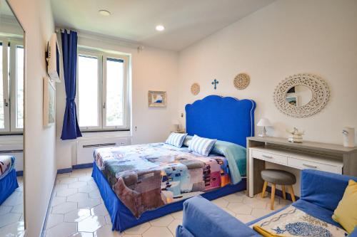 1 dormitorio con cama azul y escritorio en Bellavista su Amalfi, en Amalfi