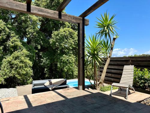 a patio with two chairs and a swimming pool at Vallegrande Nature Resort by Geocharme in Cefalù