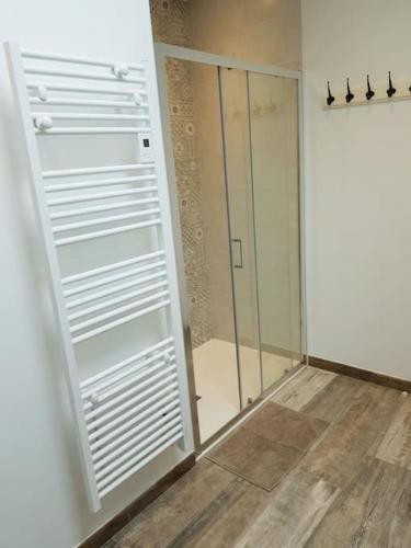 La salle de bains est pourvue d'une cabine de douche en verre et d'une porte. dans l'établissement Gîte à Saint André des Eaux, à Saint-André-des-Eaux