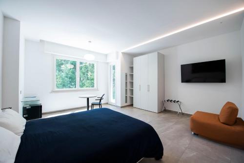 a bedroom with a bed and a table and a tv at Le Relais du Lierre in Poggio
