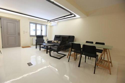 a room with a table and chairs and a couch at Elegant studio at the Acropolis hills in Athens