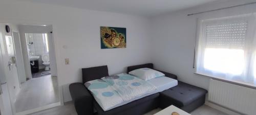 a small bedroom with a bed and a window at Blu Home/Ferienwohnung in Ostrach