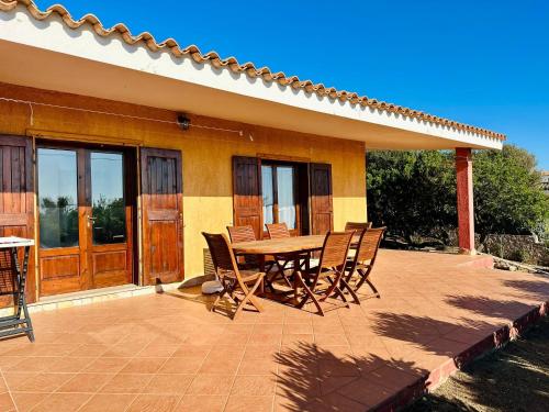 a patio with a table and chairs in front of a house at Oleandro, Rena Majore in Rena Majore