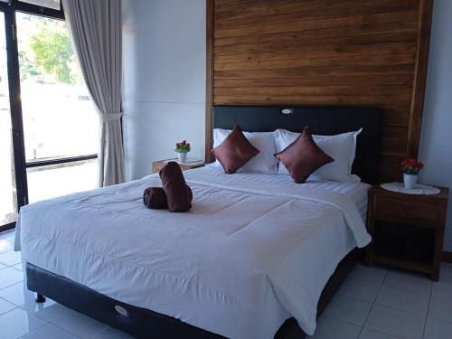 a bed with a teddy bear sitting on top of it at Ega S Hostel in Nusa Penida