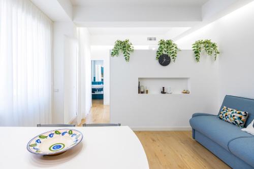 a white room with a bed and a blue couch at Residence Panoramic in Maiori
