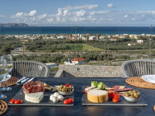 a table with cheese and vegetables on a table with a view at Terra Della Salvia in Crete in Gournes