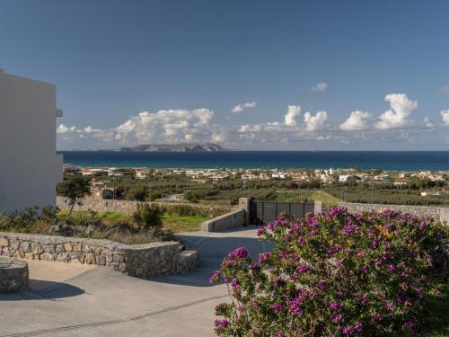 a view of the ocean and a city with flowers at Terra Della Salvia in Crete in Gournes
