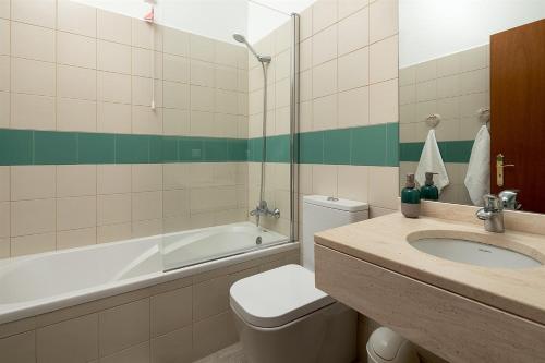 a bathroom with a sink and a toilet and a tub at Pérola Views Inn by Madeira Sun Travel in Porto Moniz