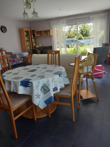 une salle à manger avec une table et des chaises et une cuisine dans l'établissement Petite maison plain pied Clohars, à Clohars-Carnoët
