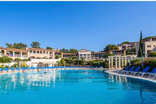 une piscine dans un complexe hôtelier avec des chaises et des bâtiments bleus dans l'établissement Appartement Résidence 