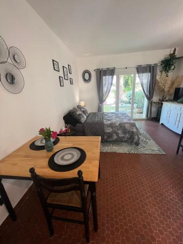 - une chambre avec un lit, une table et une table dans l'établissement Studio Cosy, à Ploemel