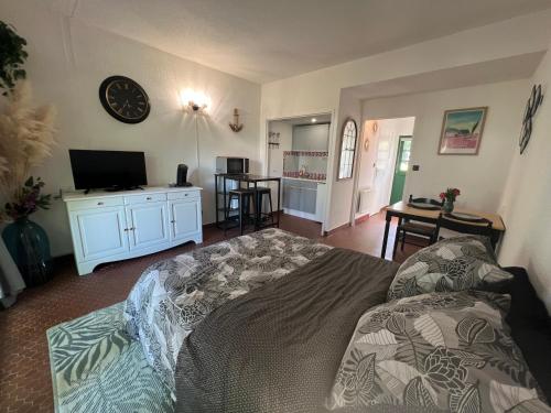 un salon avec un lit et une télévision à écran plat dans l'établissement Studio Cosy, à Ploemel