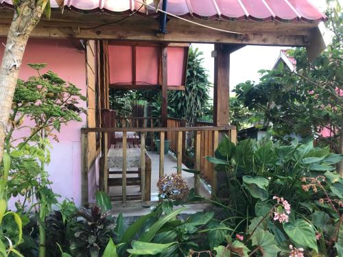 a balcony of a house with a chair and plants at Bungalow Paer Doe in Sembalunbumbung