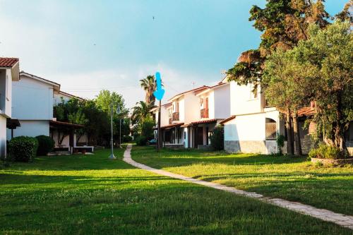 a house with a green yard with a path at Seaside Mikiverna Cozyhome in Kalyves Poligirou