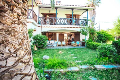 a house with a balcony and a yard at Seaside Mikiverna Cozyhome in Kalyves Poligirou