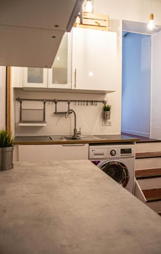 une cuisine avec des armoires blanches et un évier dans l'établissement Cosy apartment Right in Cours Mirabeau, à Aix-en-Provence