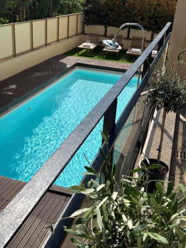 a swimming pool with a wooden deck and a swimming pool at Hôtel Gallia Cannes in Cannes